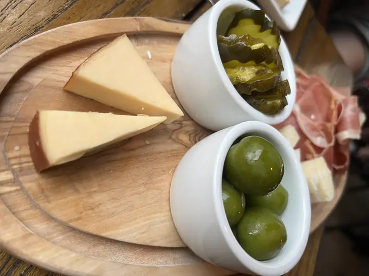 Queijo defumado em tábua com azeitonas e picles